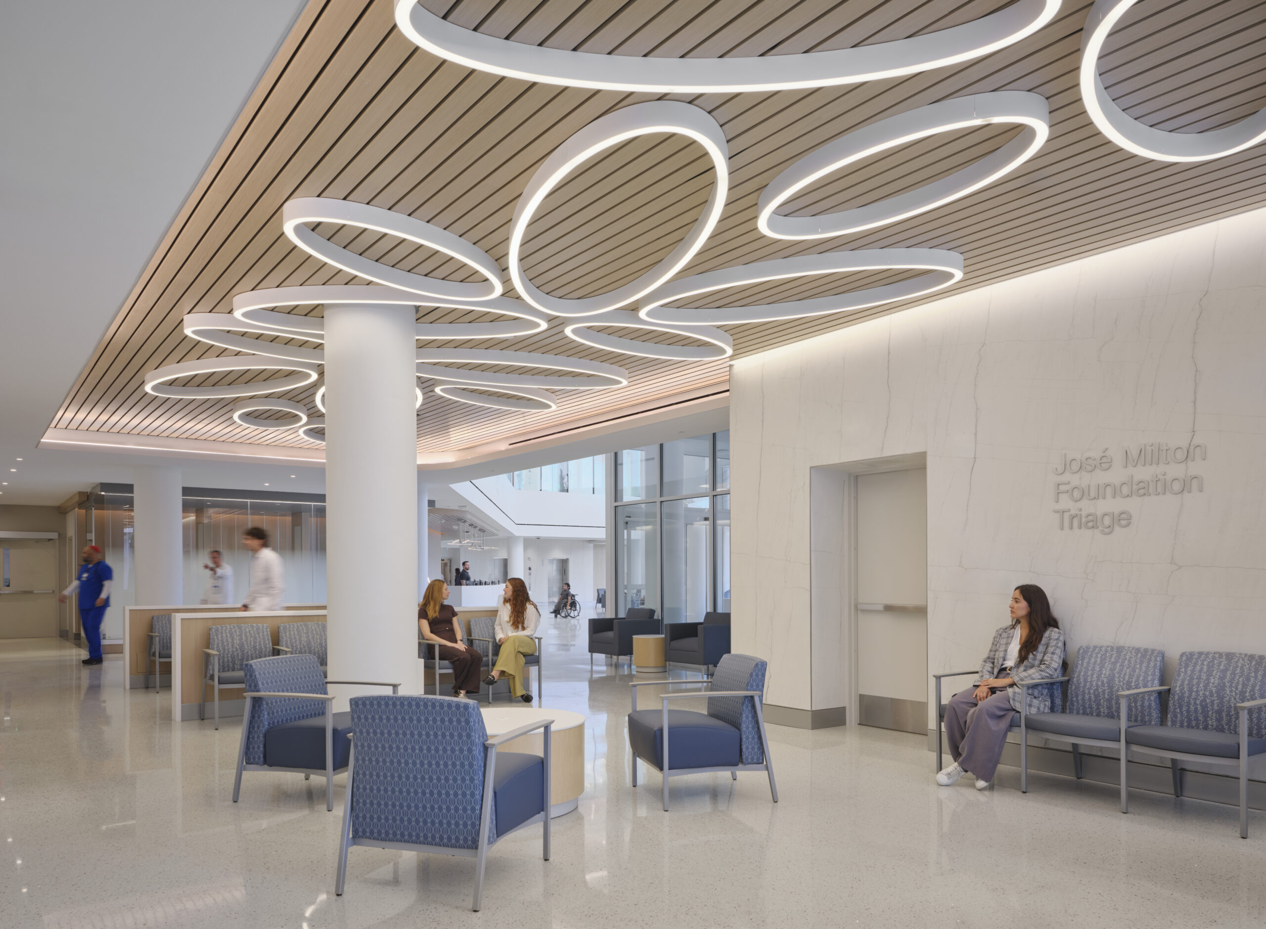 Sculptural rings of light across the wood ceiling at Jackson Memorial Hospital in Miami.