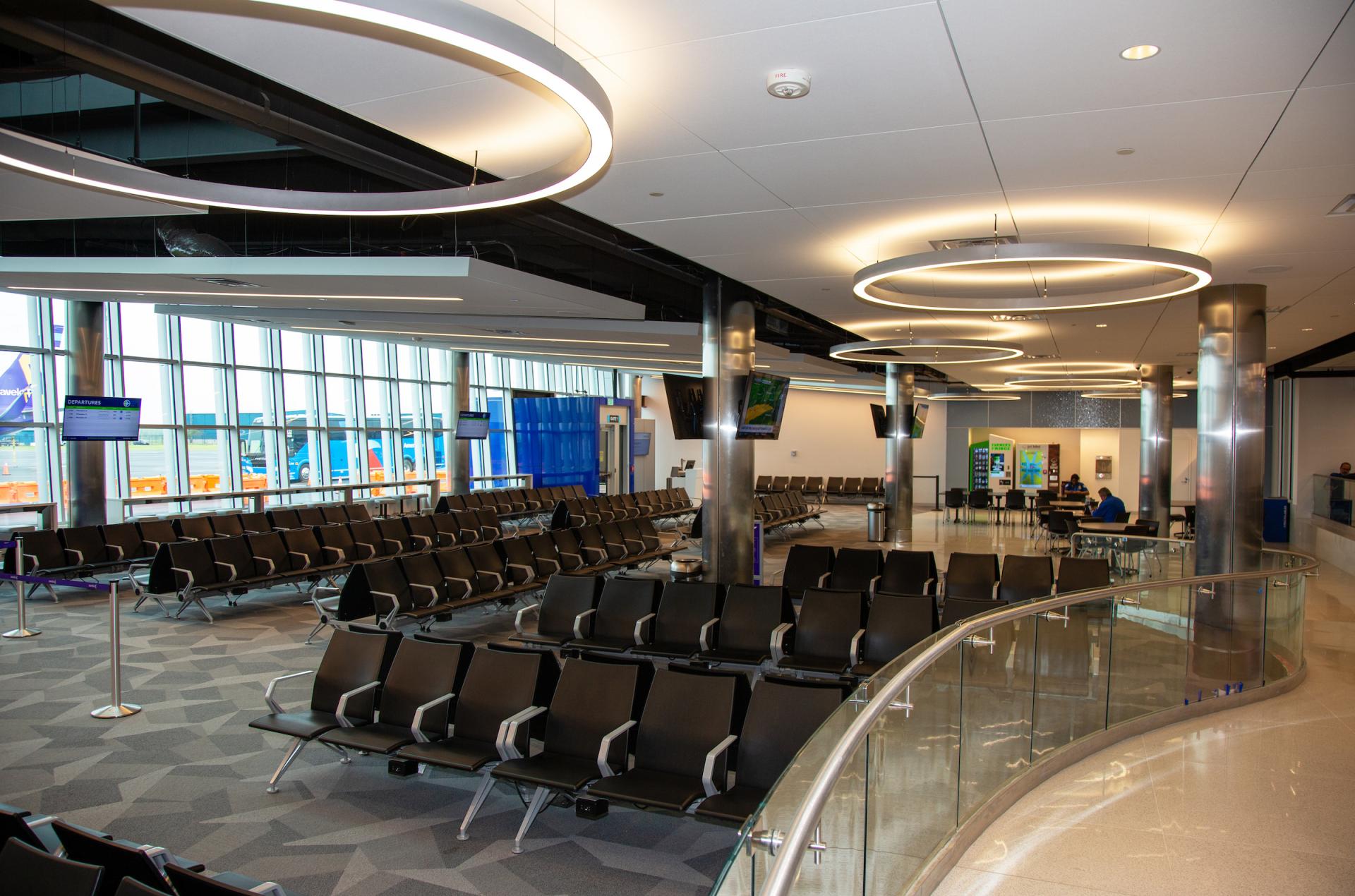 Large circular luminaires above seating in the Wilmington Airport terminal.