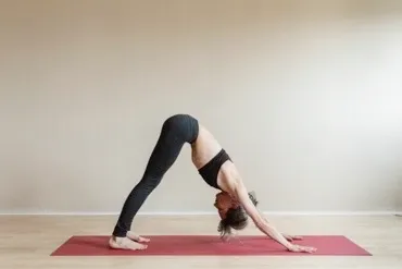 woman in black sportwear doing the downward-facing dog pose