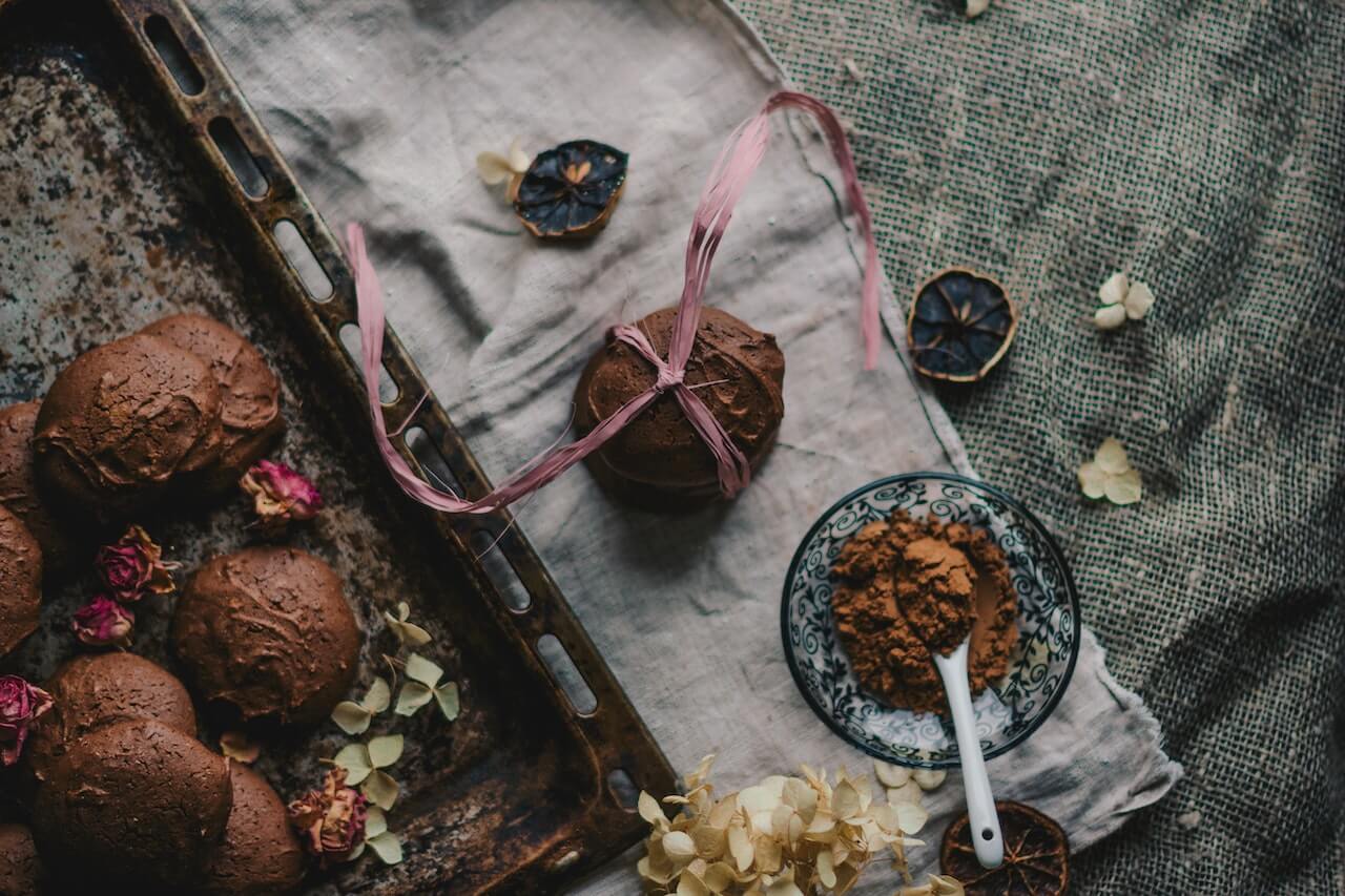 Chocolate truffles with pink ribbon, cocoa powder, and dried rose petals