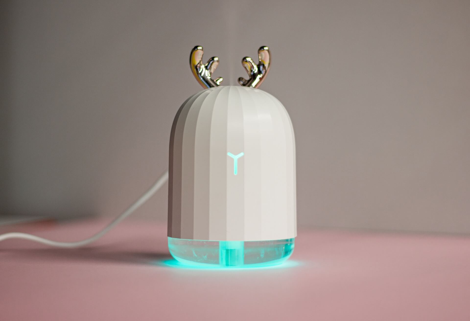 White humidifier with deer antler design and blue-green glowing base