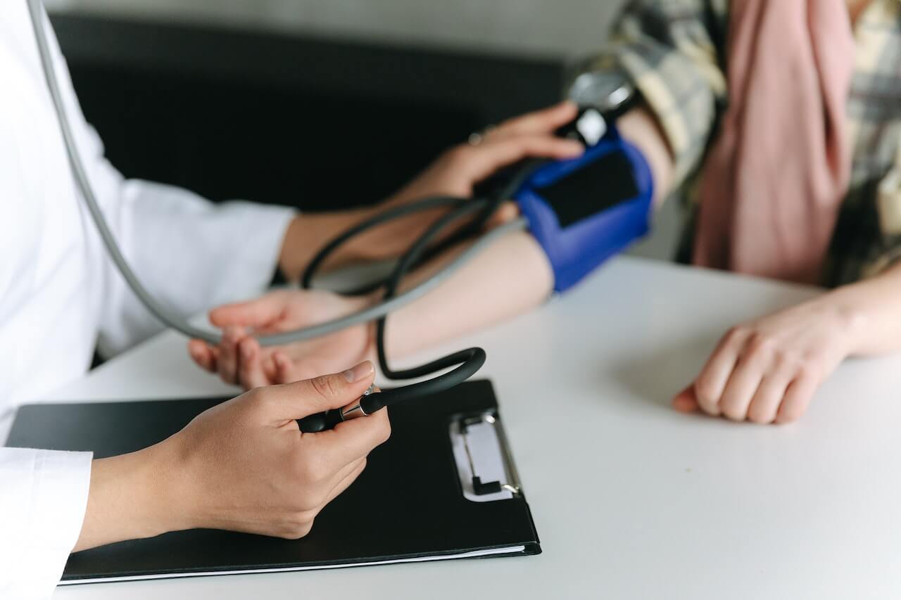 Doctor measuring patient's blood pressure during medical checkup
