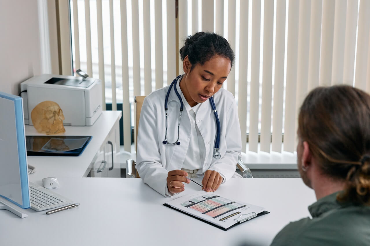 Doctor reviewing medical chart with patient in clinical office setting