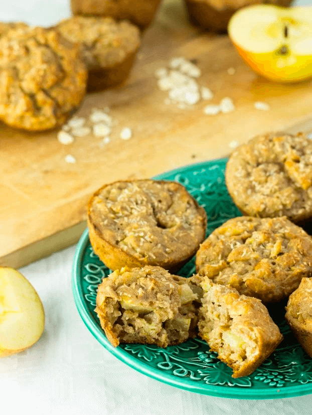 Apple oatmeal muffins on teal plate with fresh apple slices