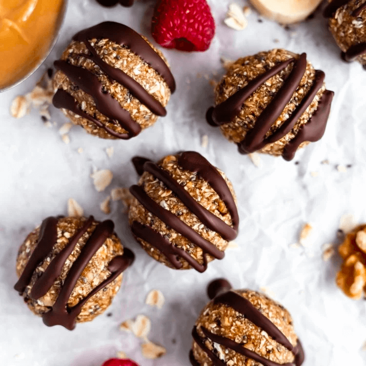 Chocolate-drizzled oat energy balls with raspberry and walnut garnish