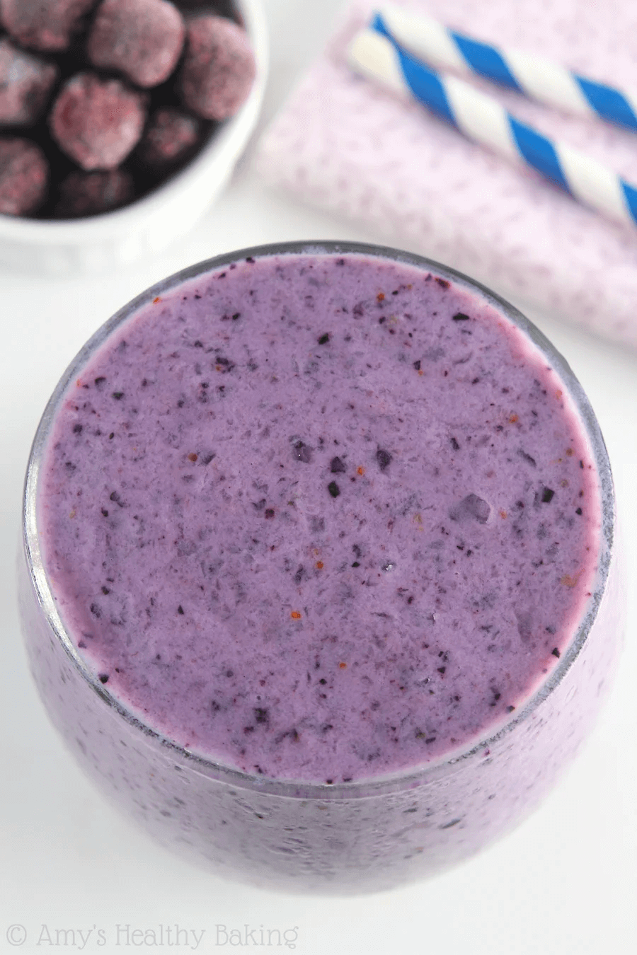 Purple berry smoothie with blended fruits in a clear glass