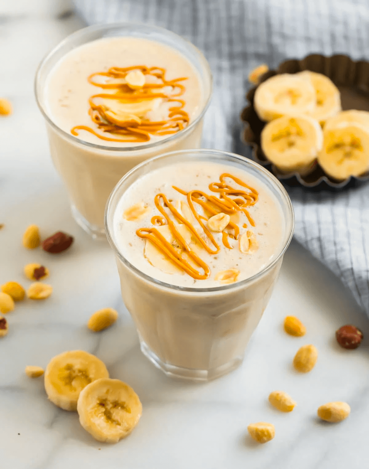 Creamy banana smoothie with caramel drizzle and peanuts