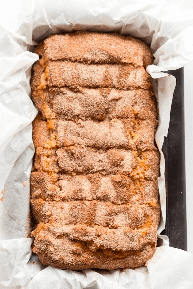 Cinnamon sugar bread loaf in parchment paper baking pan