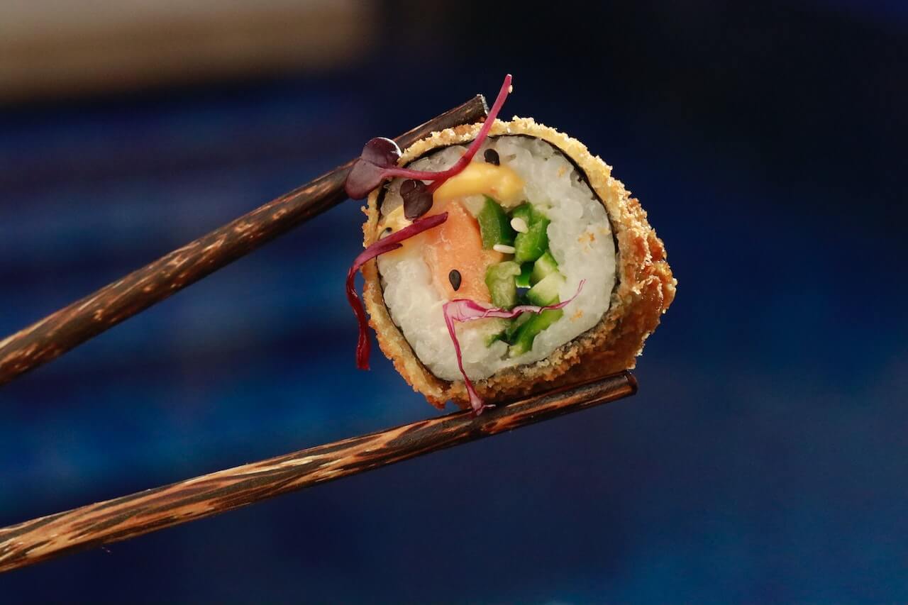 Crispy fried sushi roll with salmon, cucumber, and microgreens
