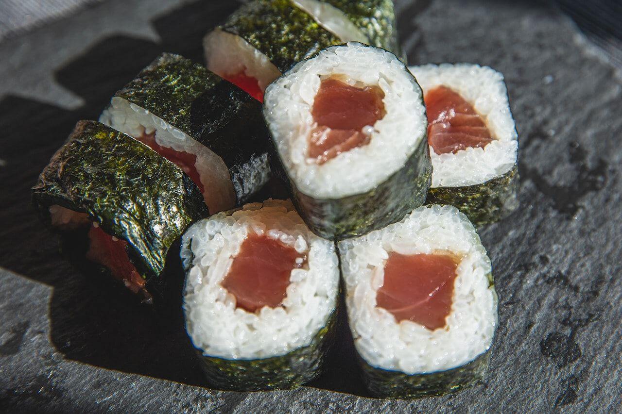 Fresh tuna sushi rolls with nori on slate background