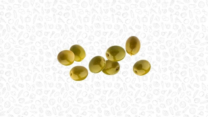 Green olives scattered on a white textured background