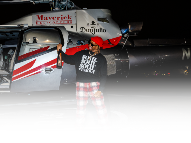 Lil Jon poses with Don Julio Bottle standing in front of a helicopter. Brought to you by Plural, NYC: Experts in Social Media Marketing Strategy and High-Quality Content Production.