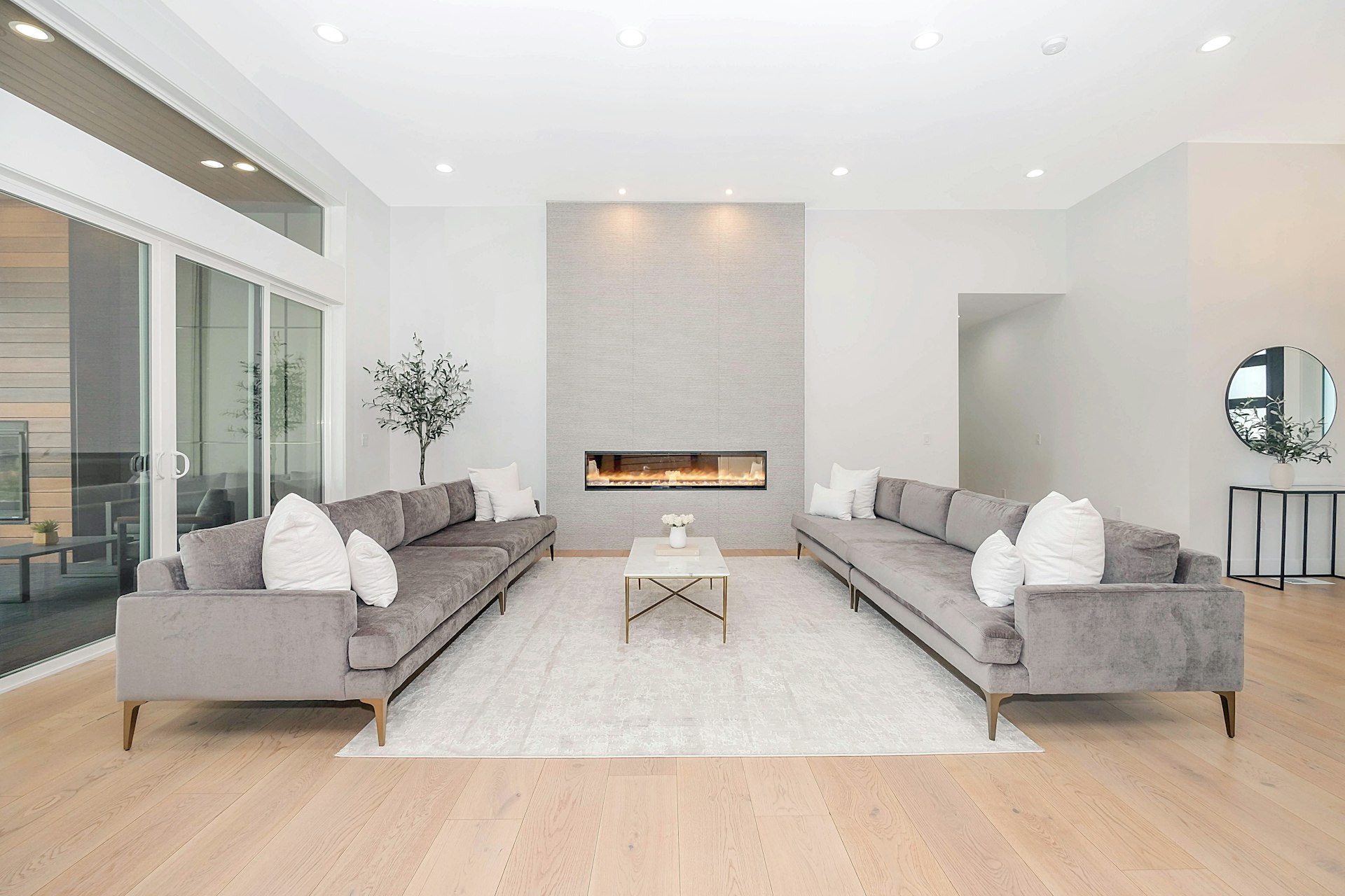 A bright, freshly cleaned modern living room with two sofas and large windows
