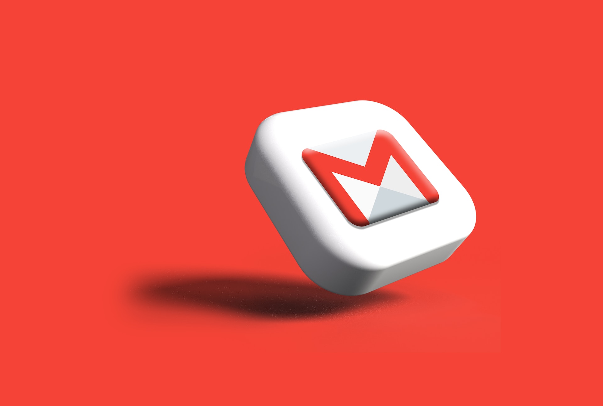 A 3-D gmail icon floats diagonally in front of a red background