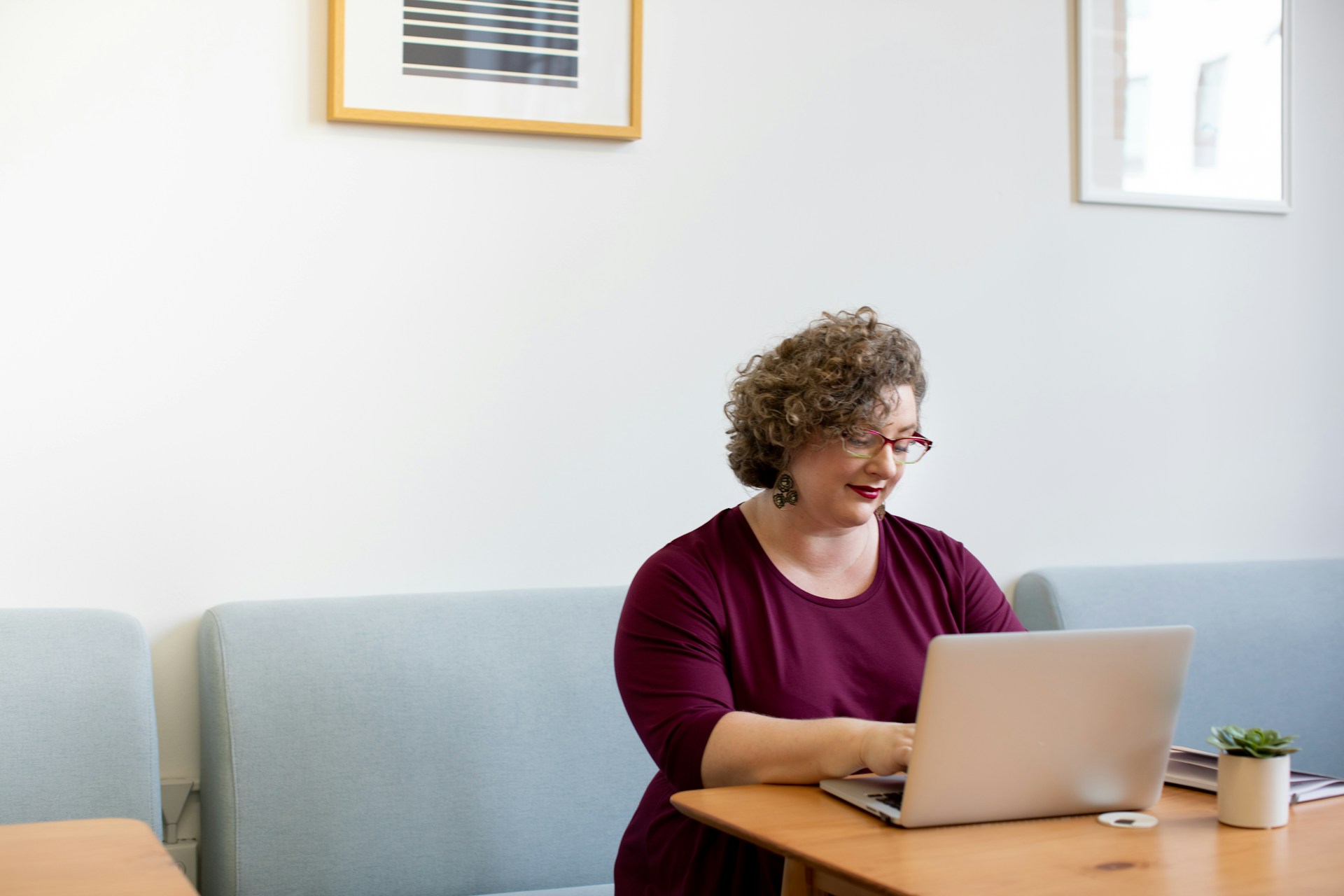 Plus size woman at work in bright, open office workplace with computer