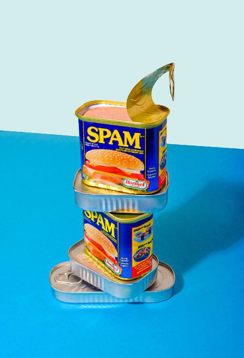 A papaya with a yellow flower perched on top of it against a blue and orange backdrop.