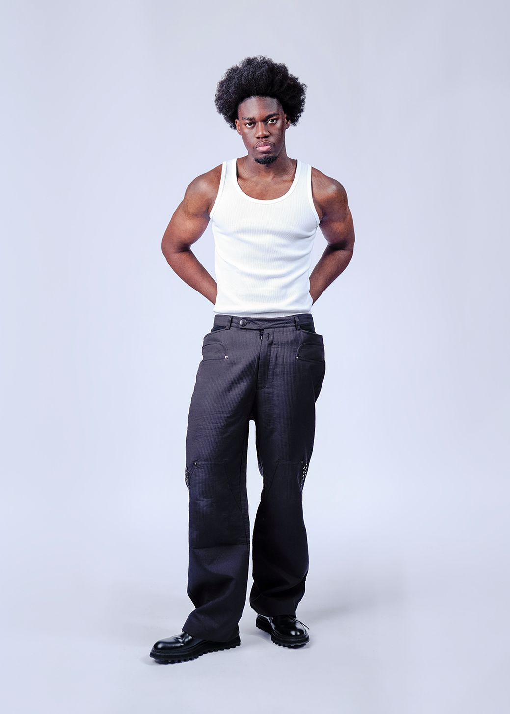 Still life of oranges, limes and avocados against a green backdrop.