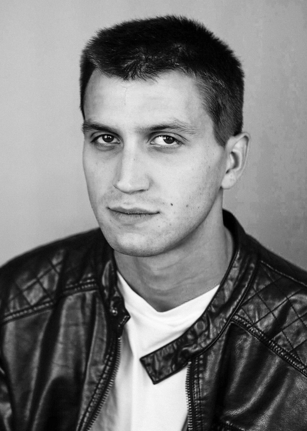 Still life of oranges, limes and avocados against a green backdrop.