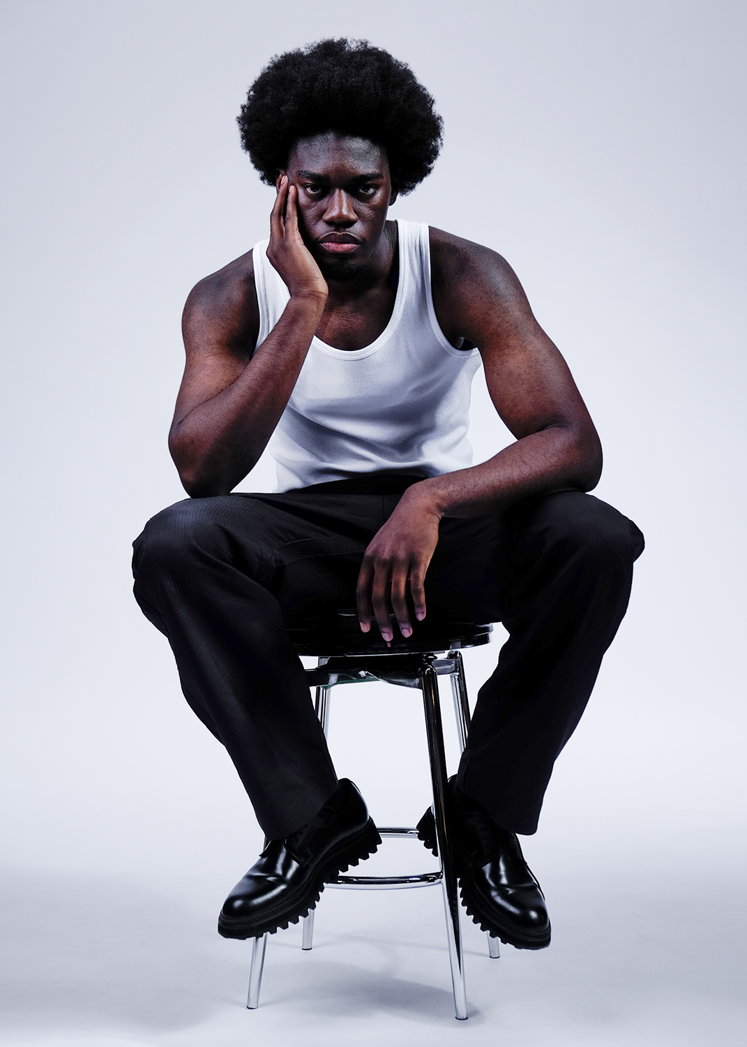 Still life of oranges, limes and avocados against a green backdrop.