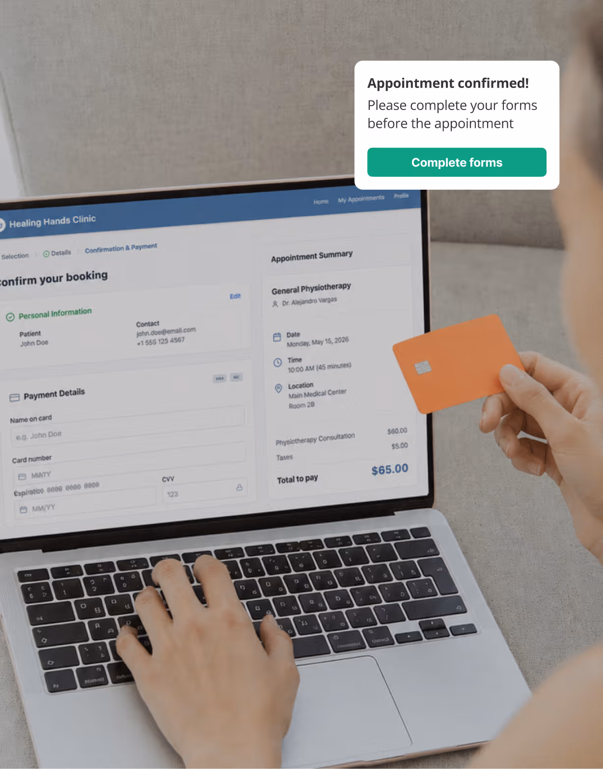 Person holding an orange credit card and entering payment details on a laptop screen for a physiotherapy appointment booking.
