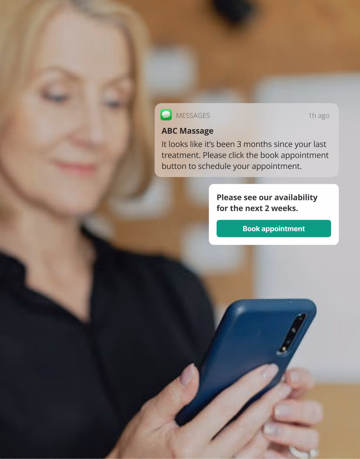 Woman holding a smartphone with notifications about booking massage appointments displayed on the screen.