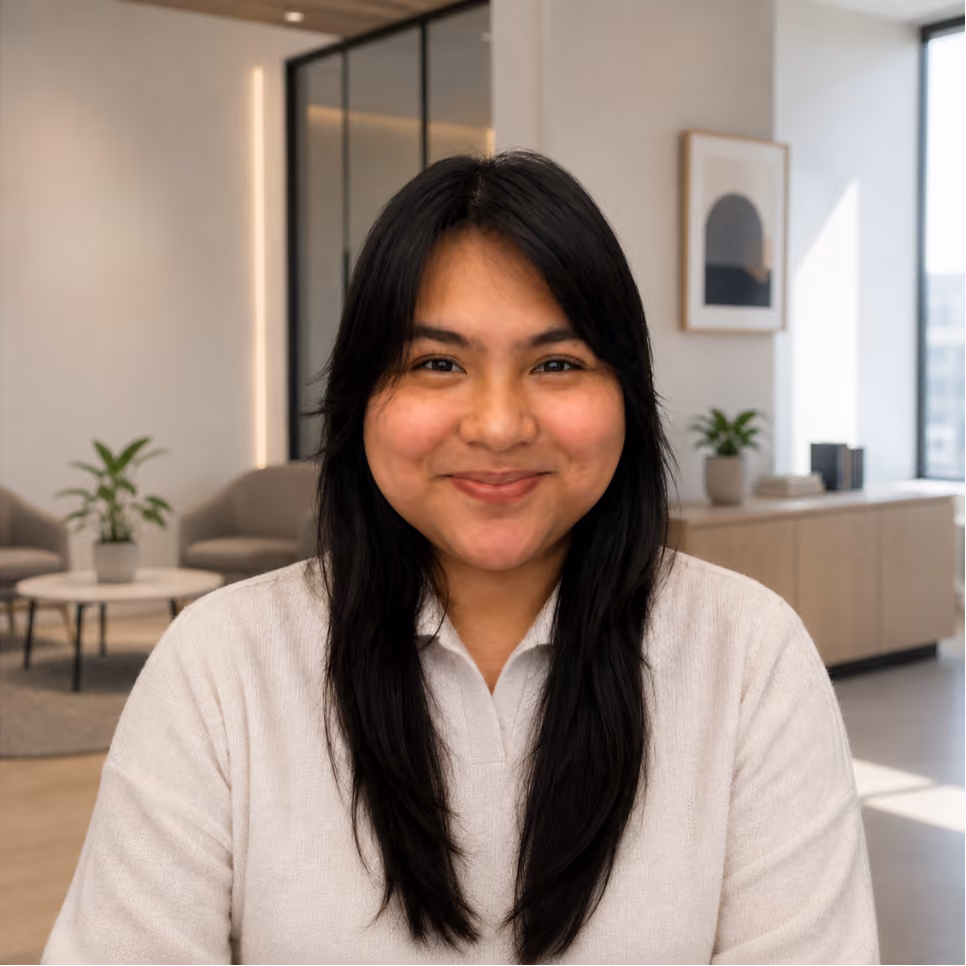Portrait of a smiling ClinicSense team member with long dark hair in a modern office.