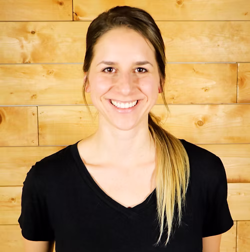 Massage therapist smiling in a client testimonial photo for ClinicSense.