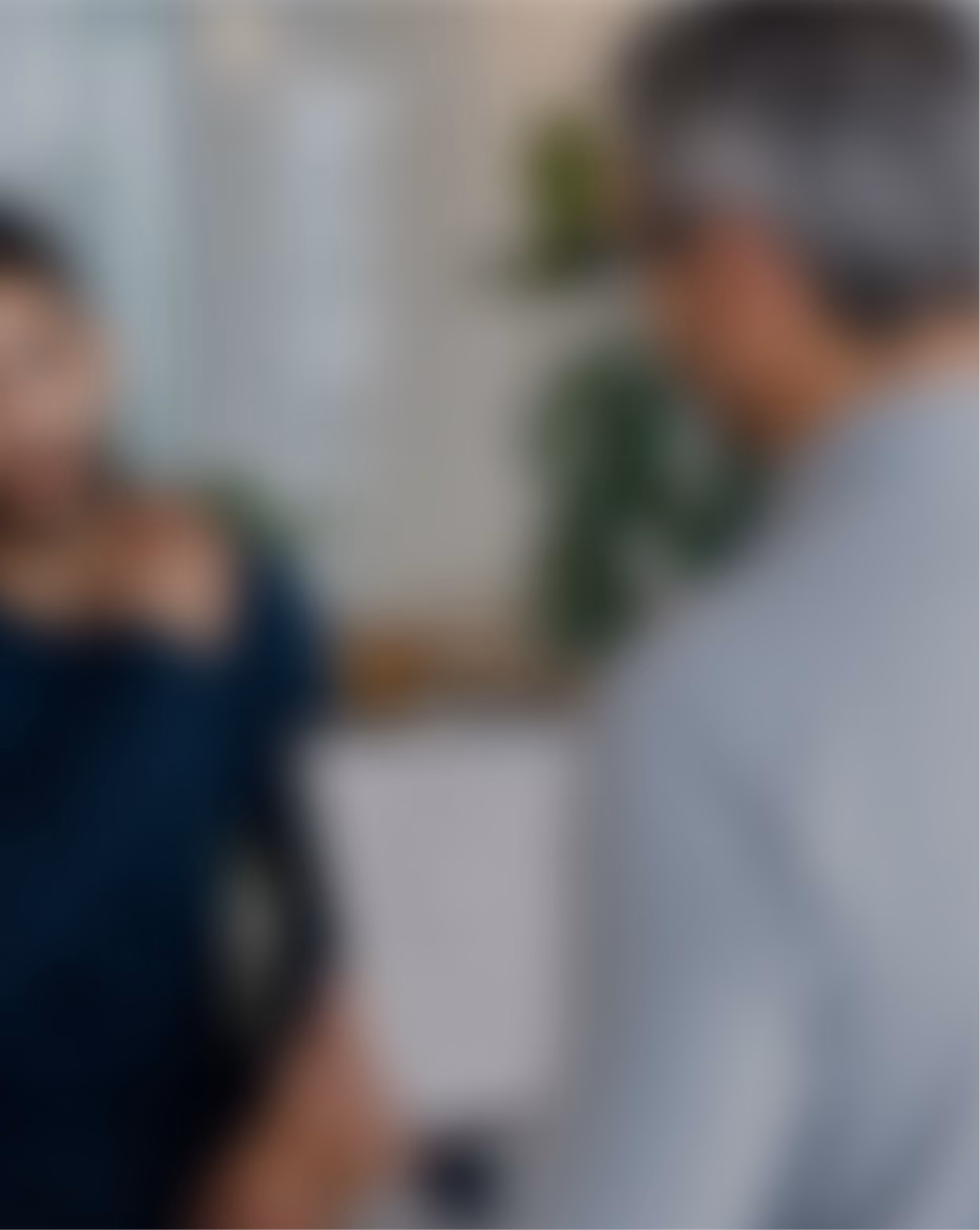Blurred background photo of a practitioner and client talking indoors.