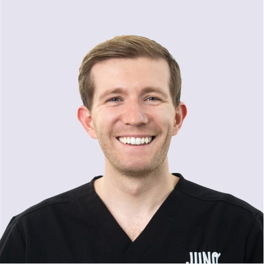 Dr. Brett Noden, veterinarian, smiling in black scrubs