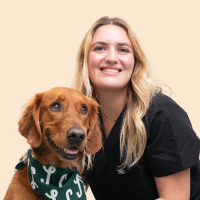 Dr. Esther smiling with golden retriever