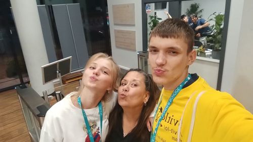 Three students making silly faces in modern building lobby