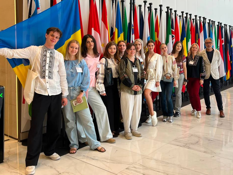 Svitlo students in front of a row of flags