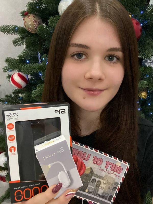 Arina holding a power bank and clip-on reading light