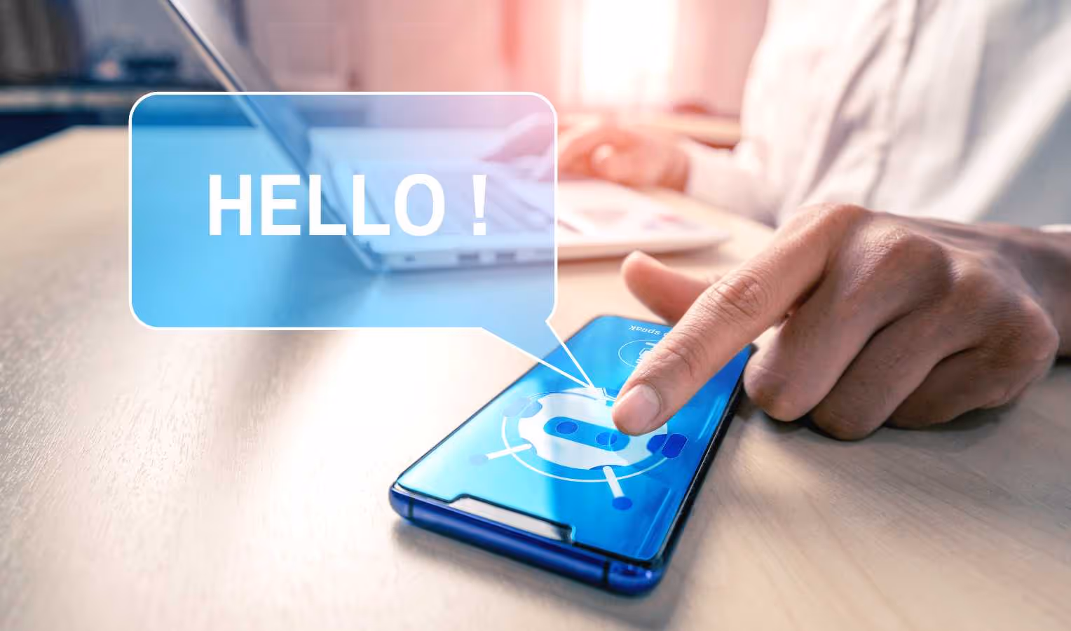 Hand tippt auf Smartphone mit Chatbot-Symbol; Sprechblase „HELLO!“ erscheint.