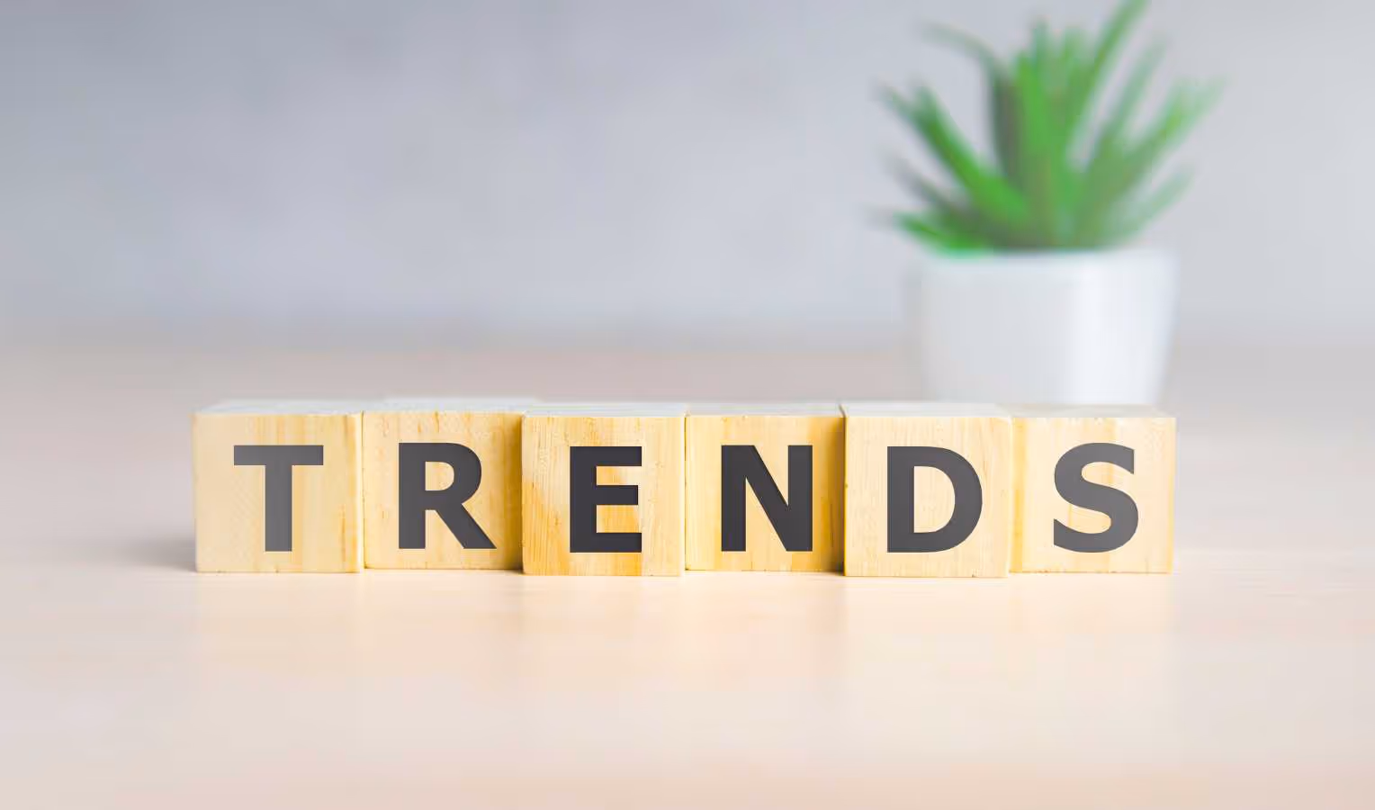Holzklötze mit Buchstaben bilden das Wort „TRENDS“ auf einem Tisch.