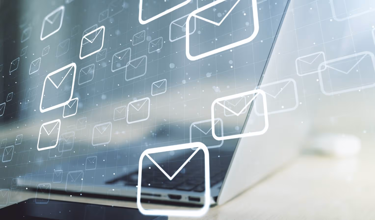 Aufgeklappter Laptop, darüber schwebende, leuchtende E-Mail-Symbole – Sinnbild für digitalen Posteingang und Kommunikation.