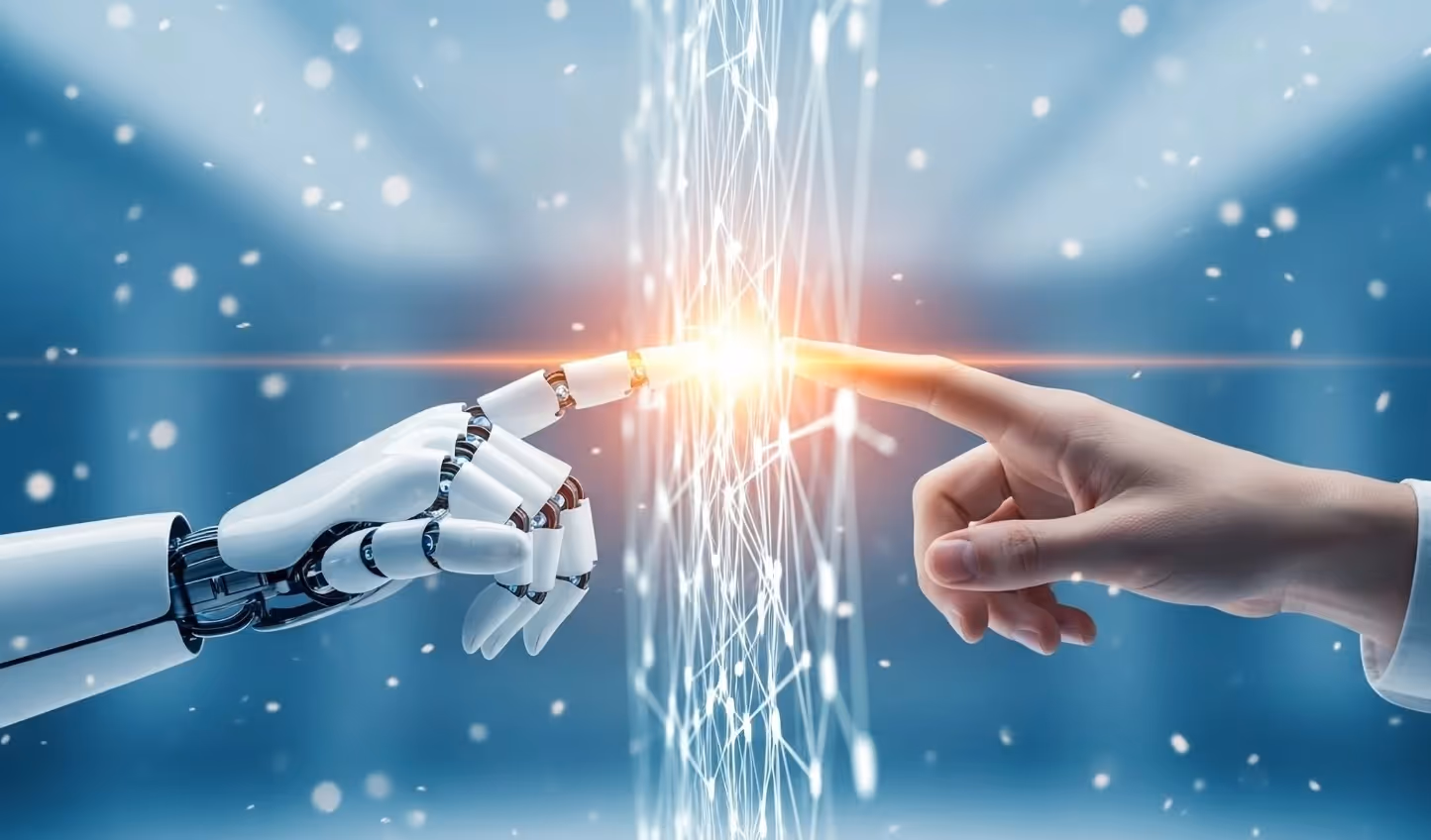 Eine menschliche Hand und eine weiße Roboterhand berühren sich mit den Fingerspitzen, getrennt durch ein leuchtendes, digitales Netzwerk auf blauem Hintergrund – Symbol für die Verbindung von Mensch und künstlicher Intelligenz.