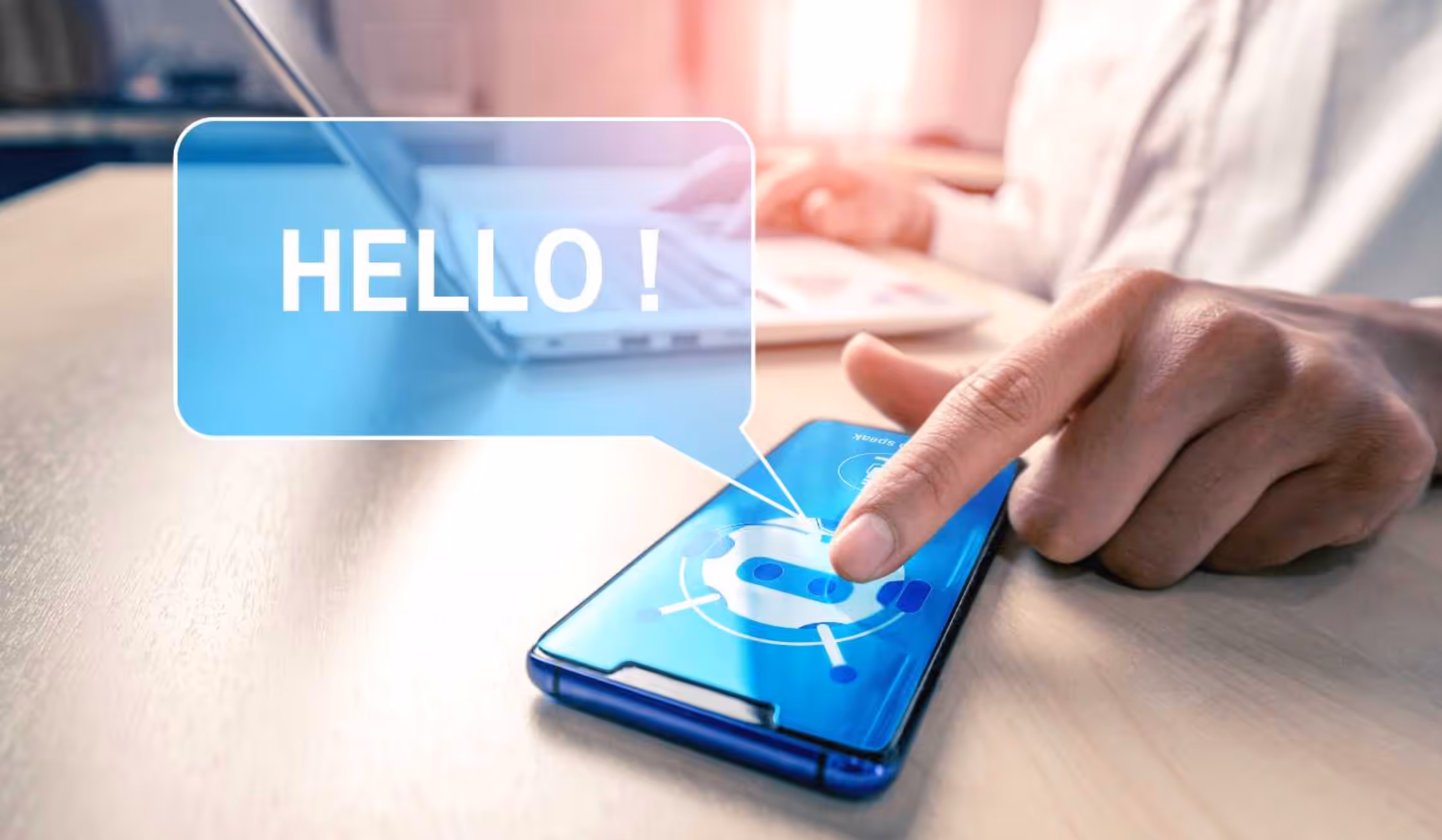 Hand tippt auf Smartphone mit Chatbot-Symbol; Sprechblase „HELLO!“ erscheint.