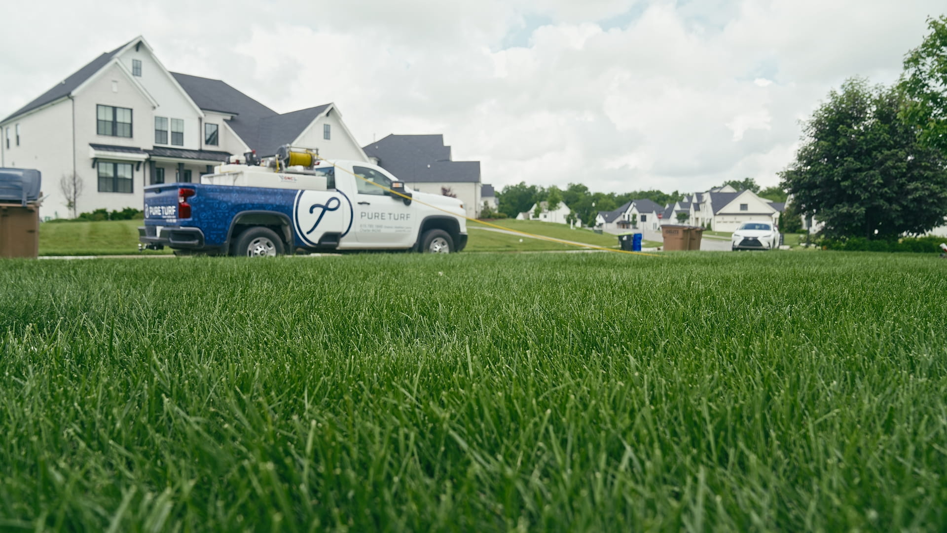 Ground-level view of turf with a Pure Turf truck in the background