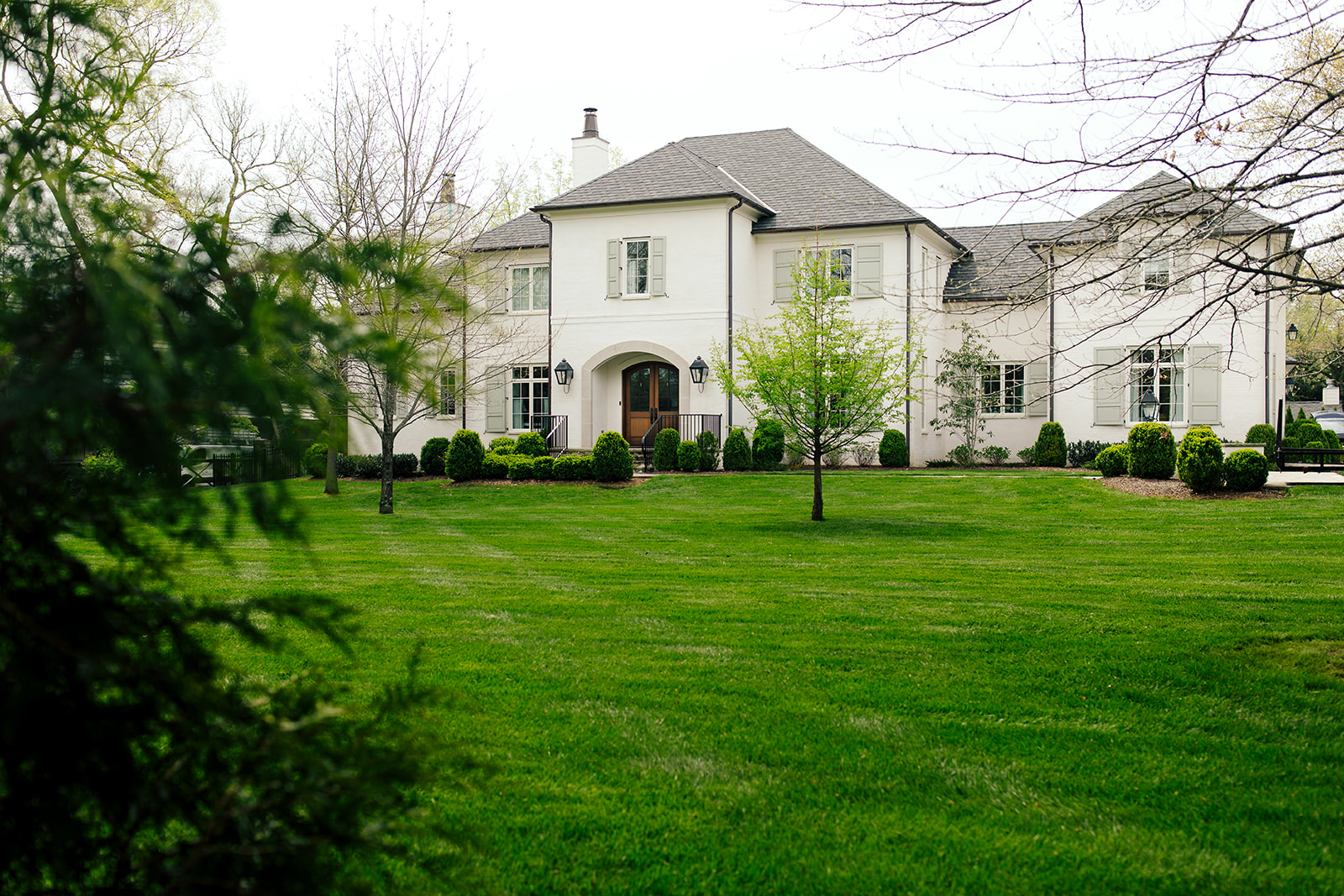Even, green lawn in front of a white home in Middle Tennessee