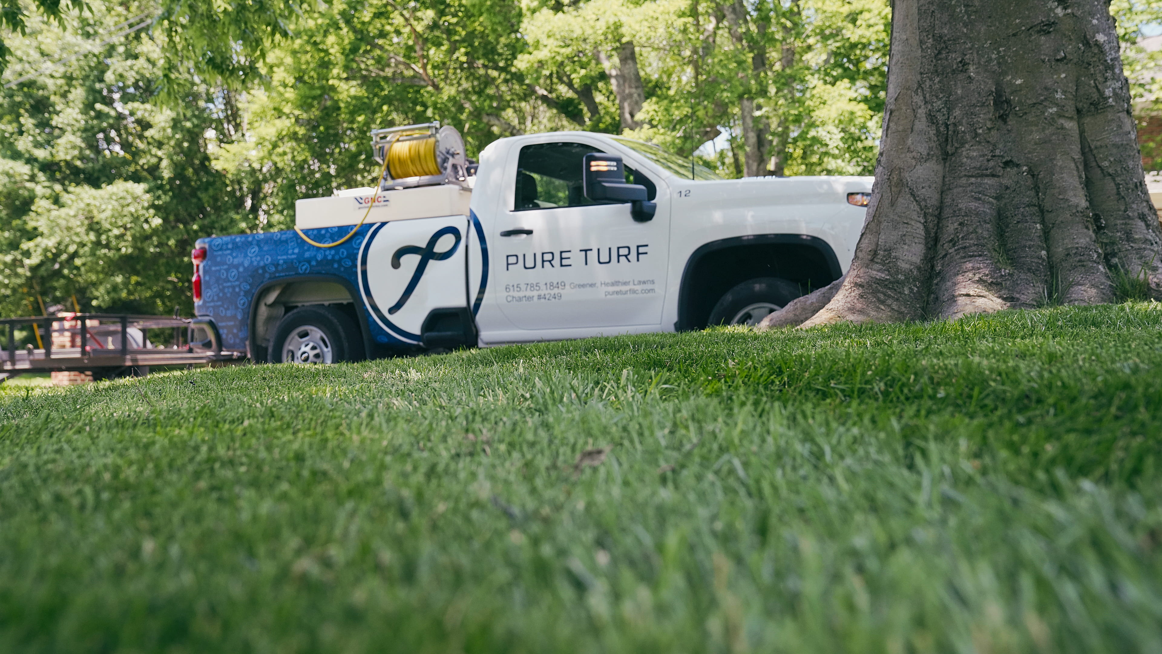 Pure Turf truck parked beside a healthy lawn