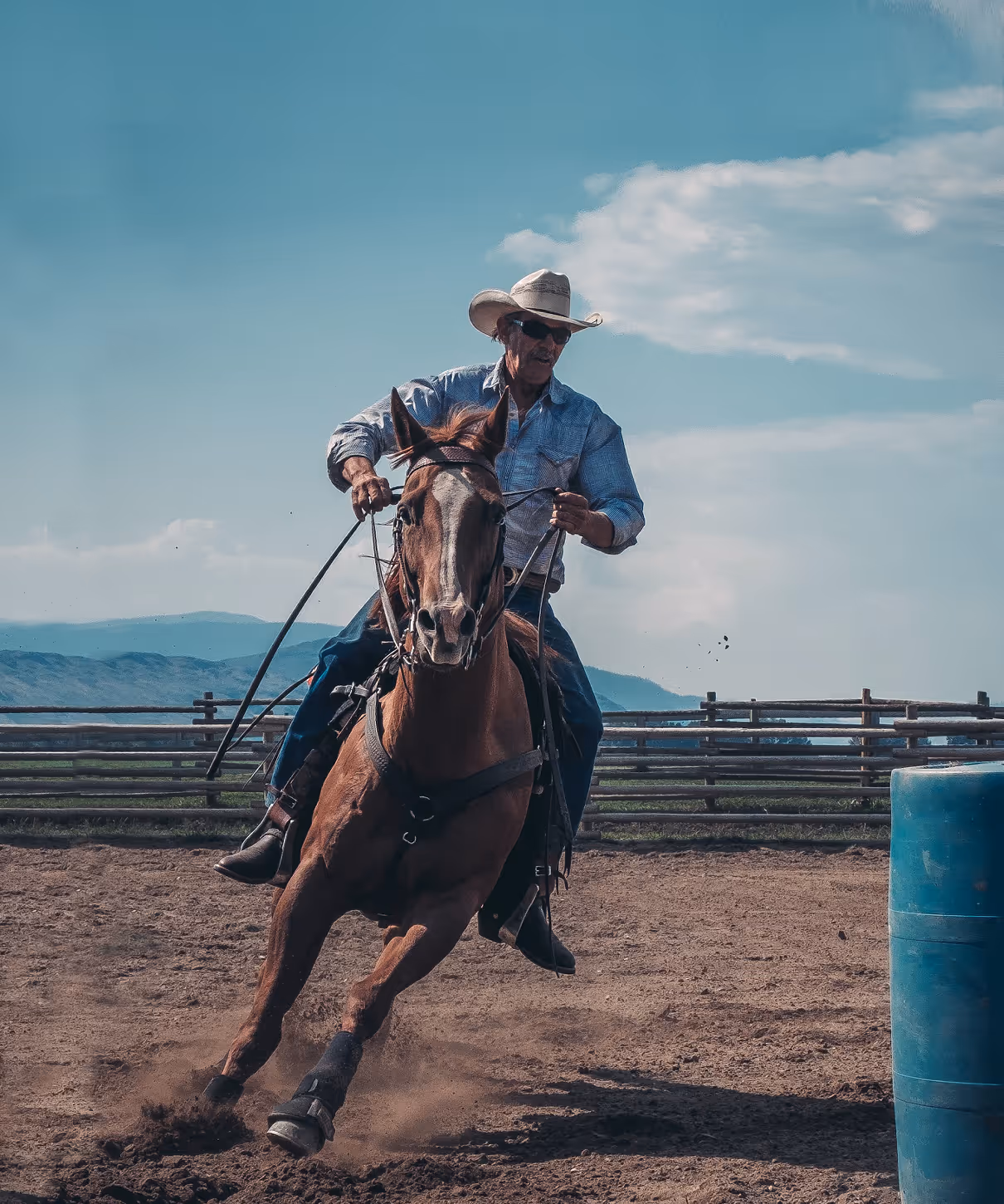 A photo of an older man ina cowboy hat riding a horse.