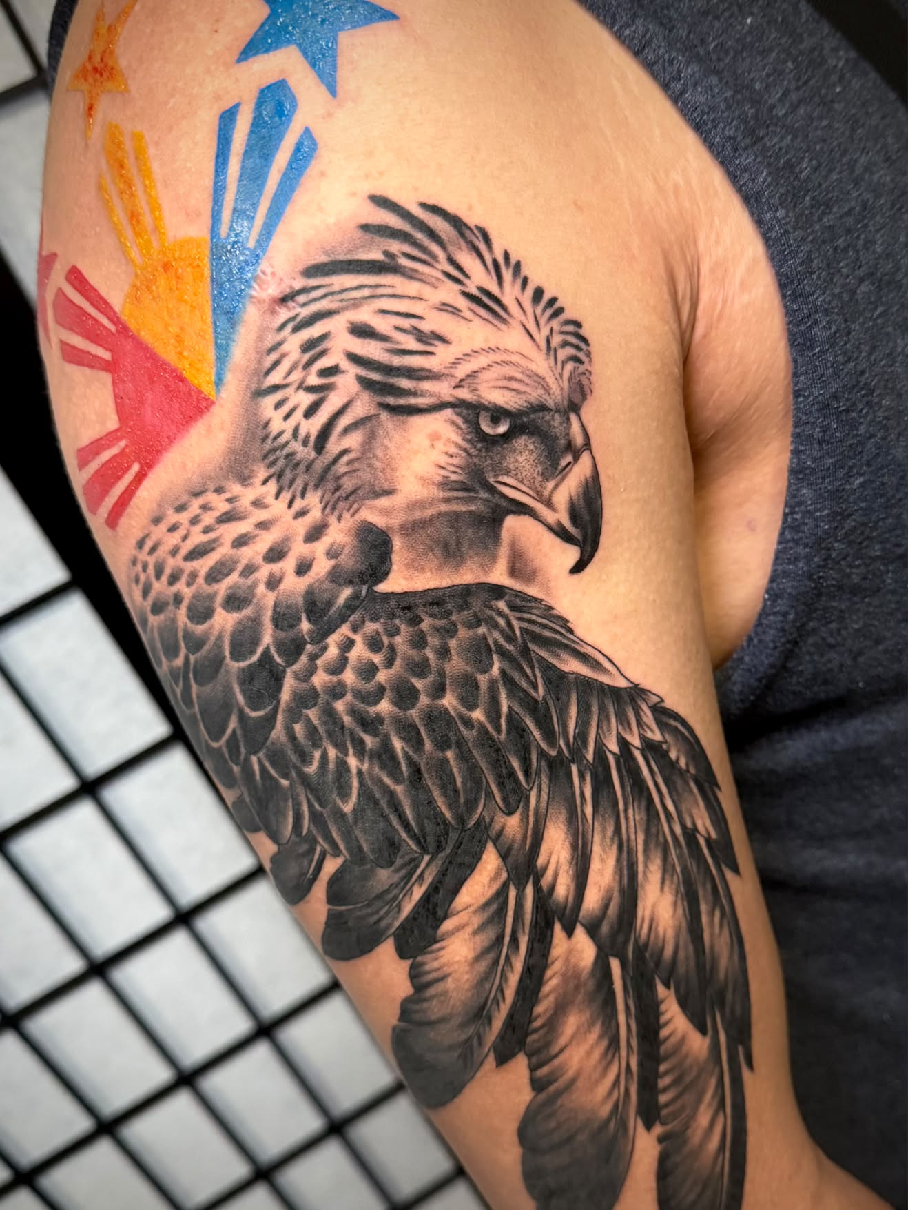 Black and grey Philippine eagle tattoo with Filipino flag sun and stars