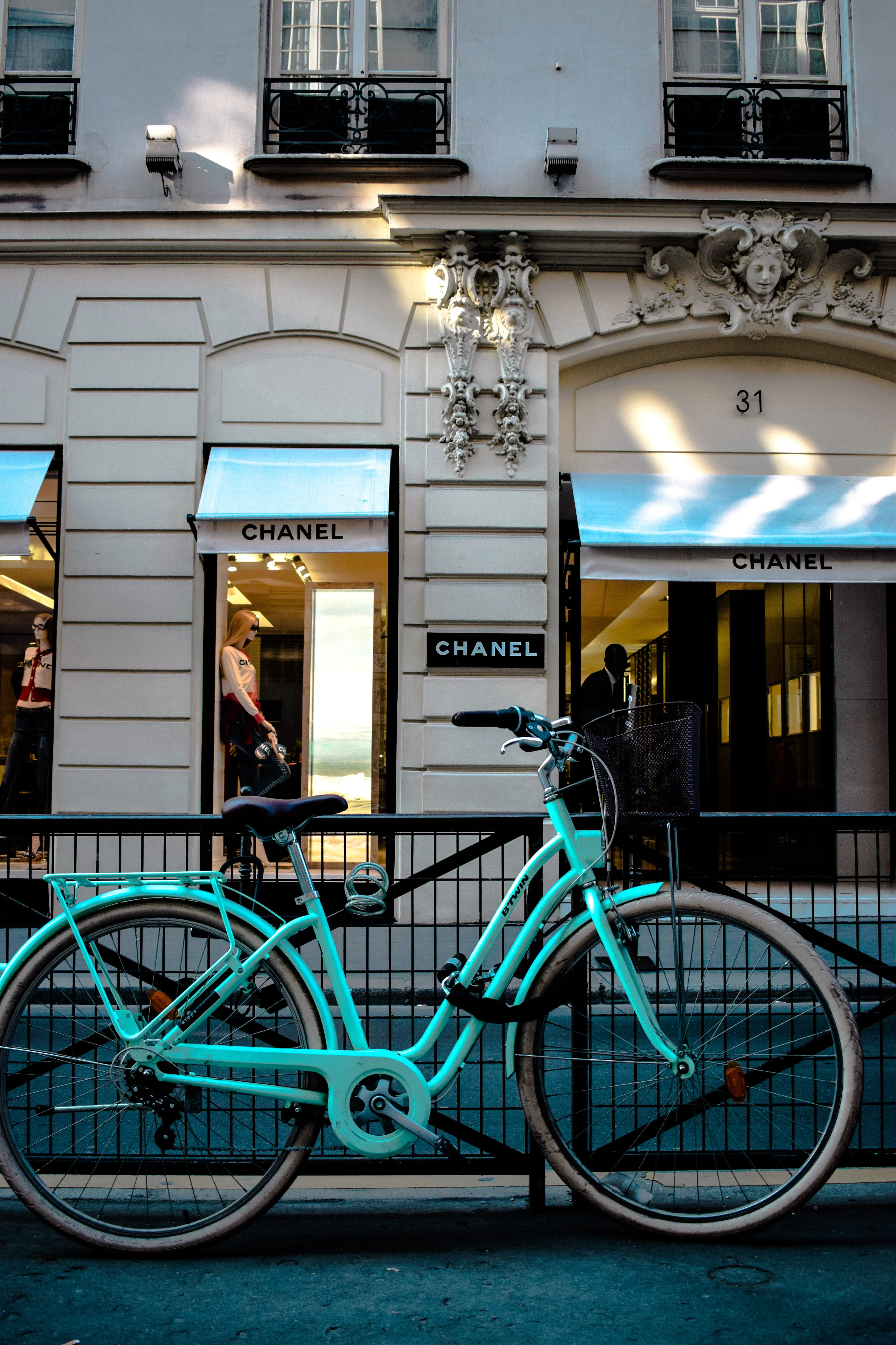 A blue bike in front of a shop in Paris.