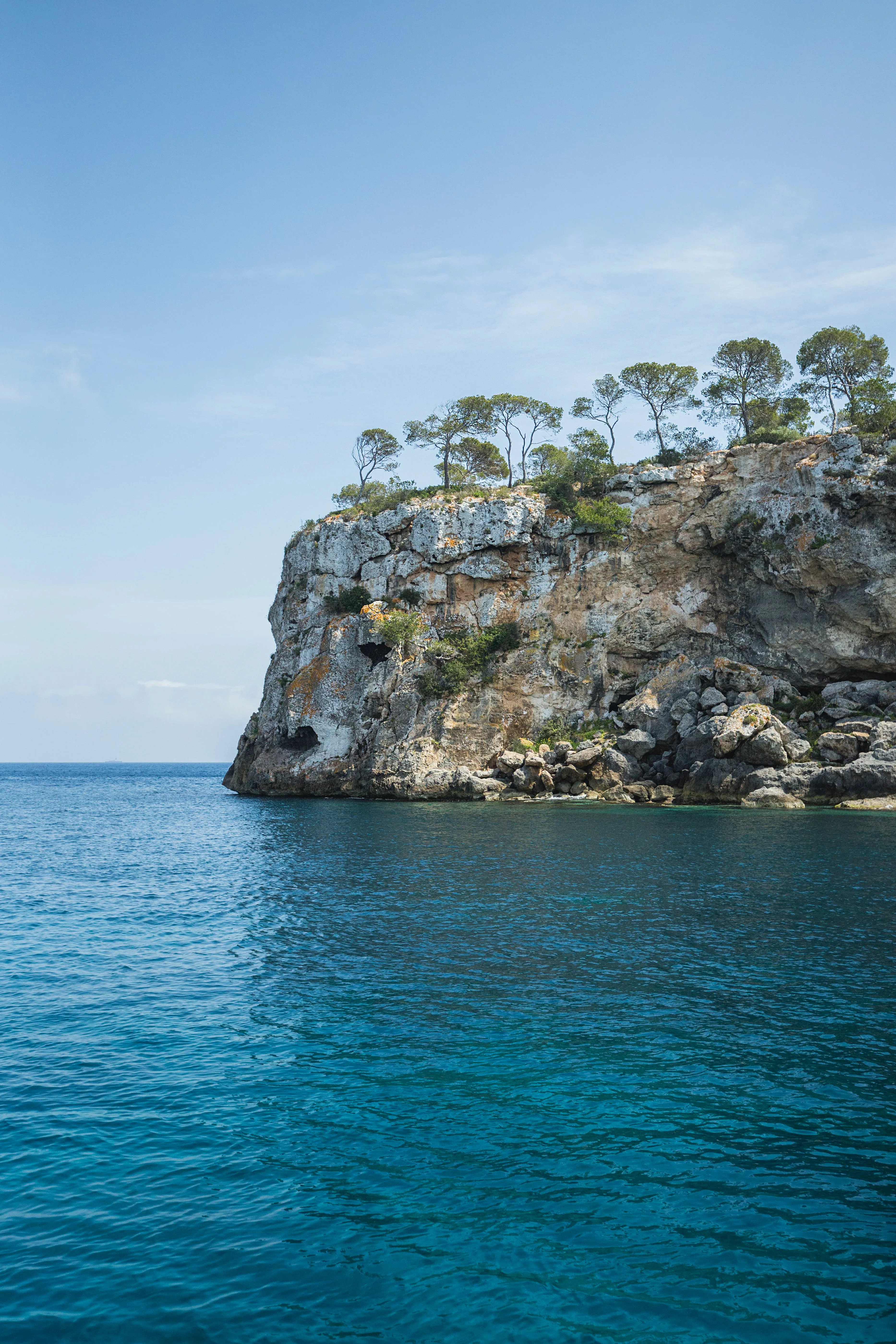 Crystal blue waters in front of a rocky cliff at the Andalusian coastline in Spain