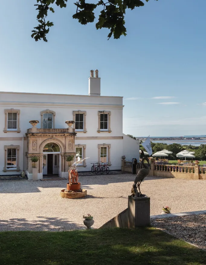 Exterior view during a sunny day with blue sky of the Lympstone Manor.