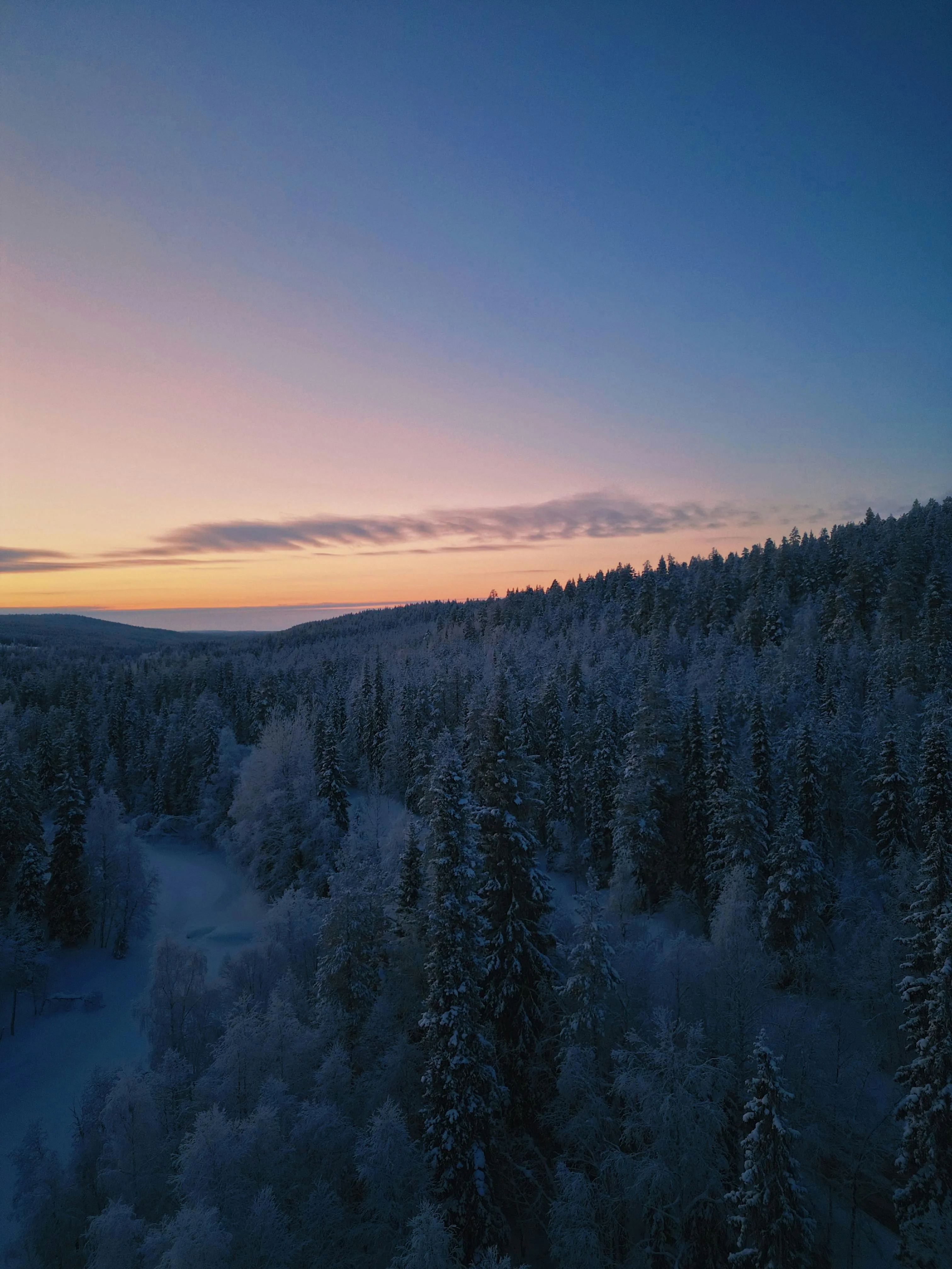 Sunset in Finland during the winter with a snowy landscape.