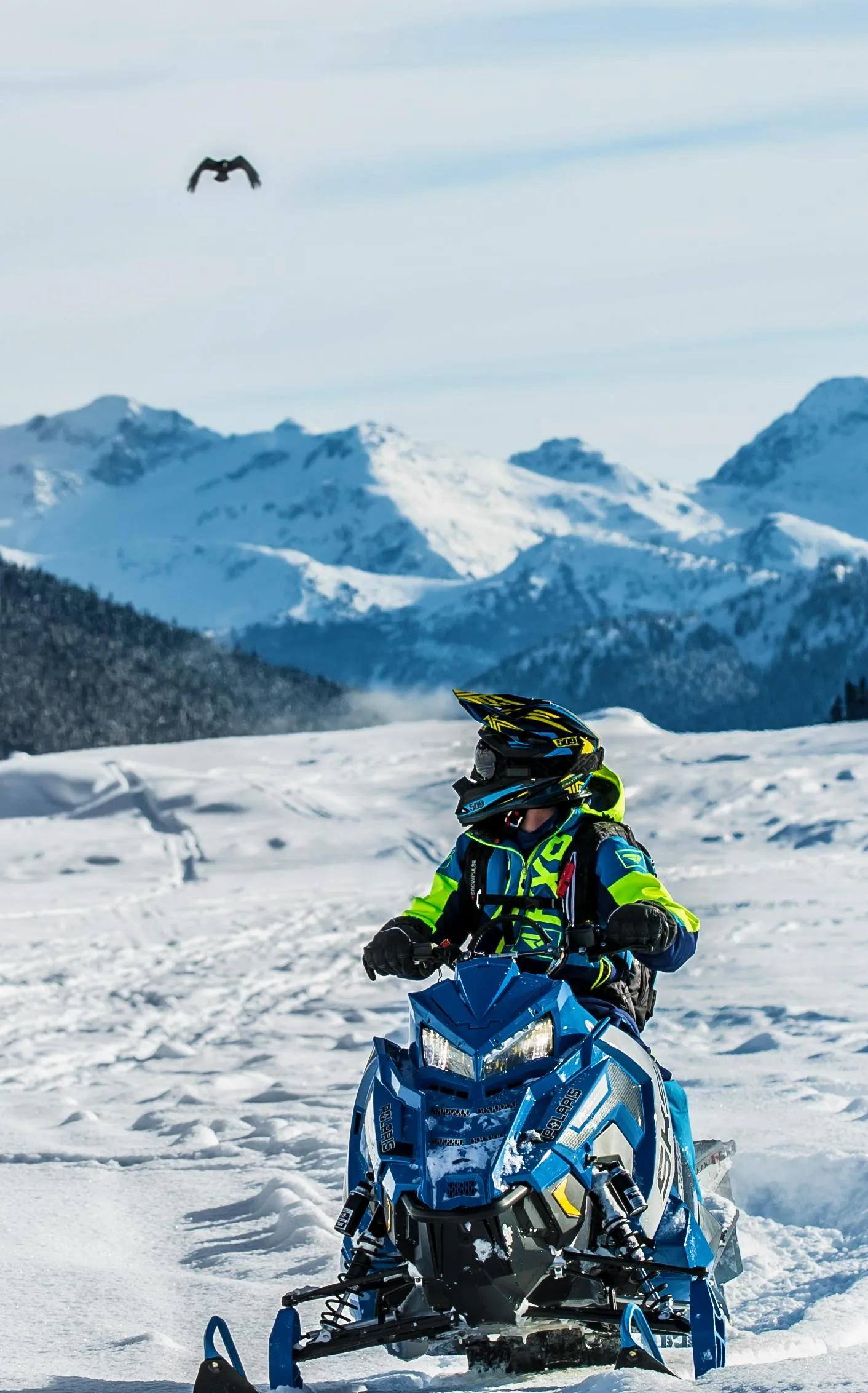 Riding a snowmobile in the snowy mountains.