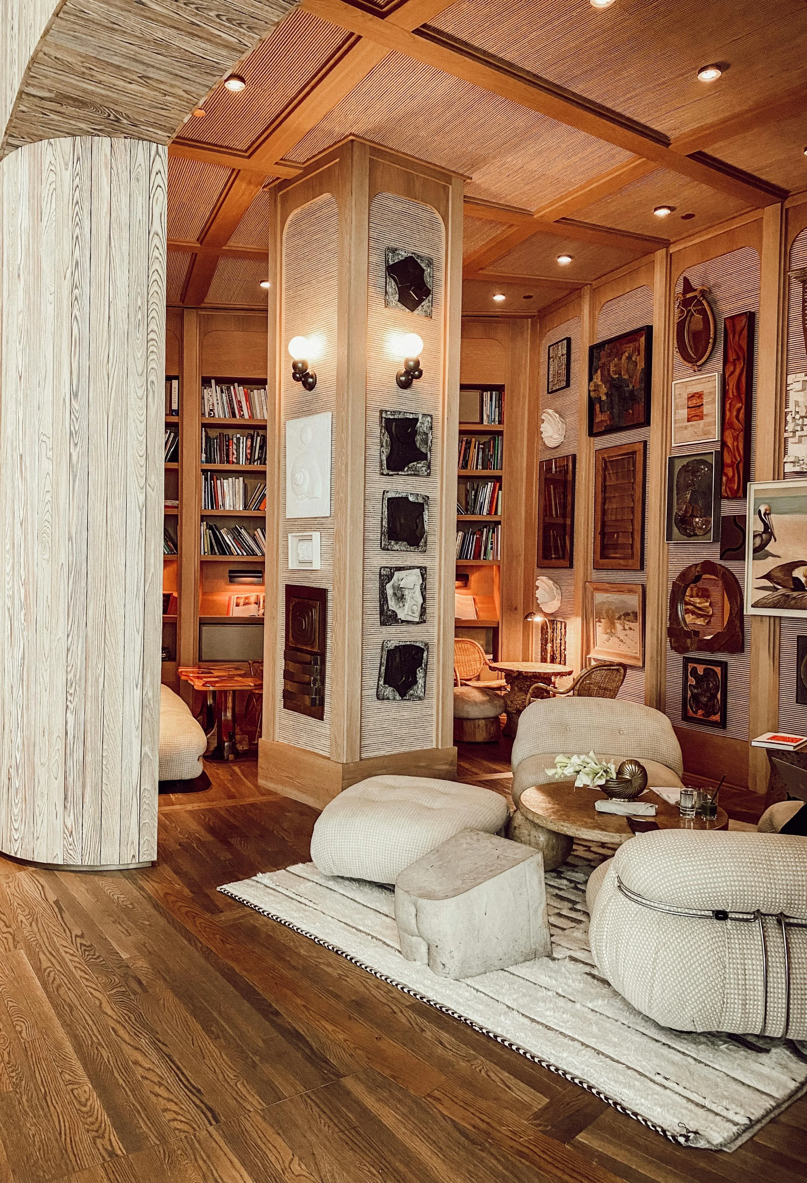 Cozy warm interior with soft chairs and many books in the cupboard.