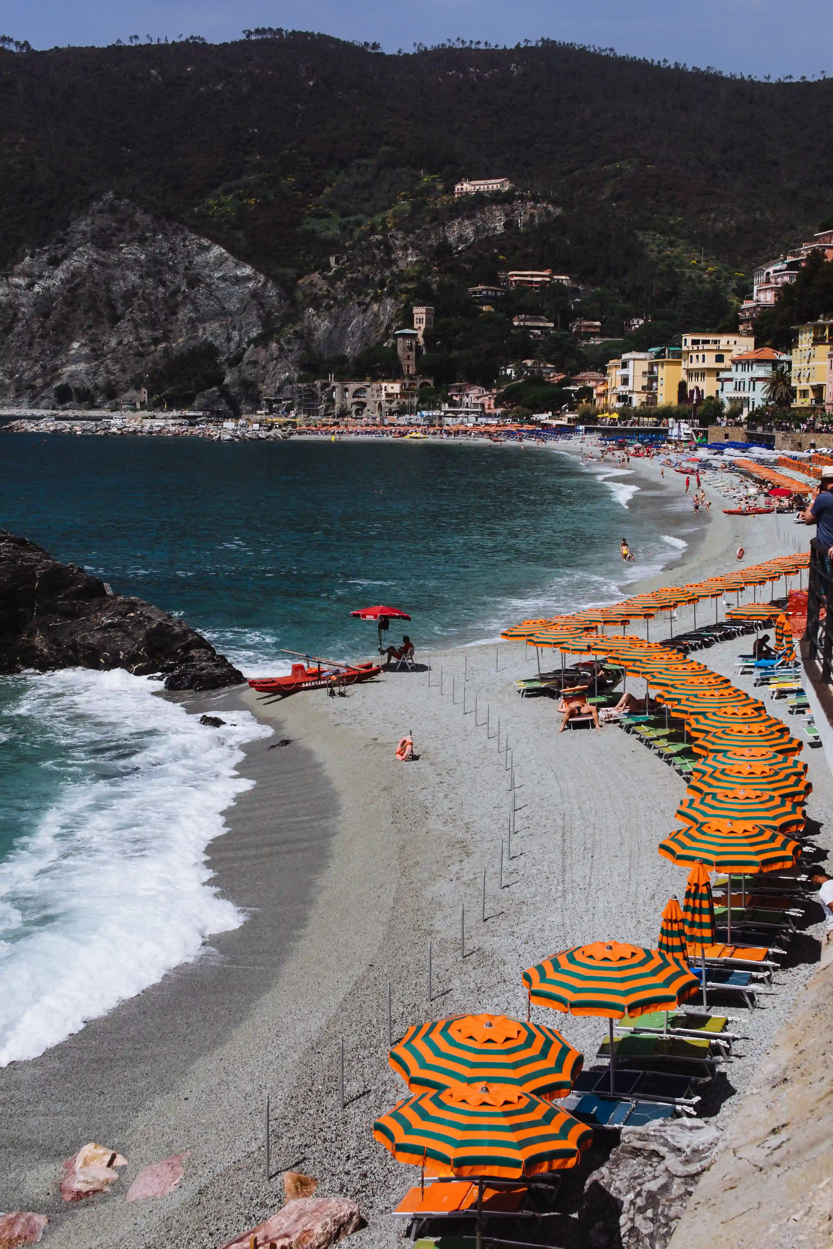 French Mediterranean Coastline with waves, blue water and a short beach with a hilly background